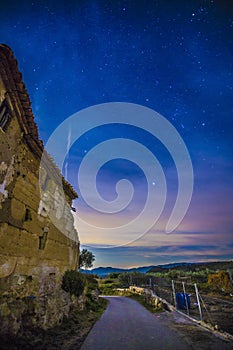 Vertical low angle shot of a building under the colorful night sky in Chelva, Valencia, Spain