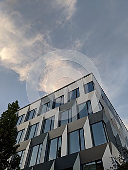 Vertical low angle shot of a glass modern building under a blue sky
