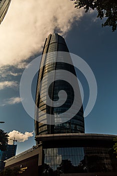 Vertical low angle shot of a high rise building with mirror windows under the beautiful cloudy sky