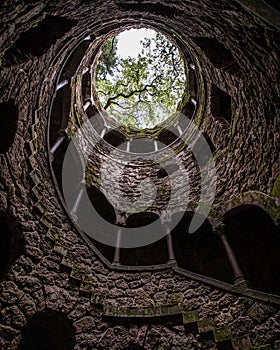 Vertical low angle shot of a spiraling castle brick tower with trees