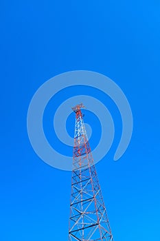 Vertical low angle shot of a tall radio tower under a clear blue beautiful sky