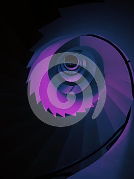 Vertical low angle shot of a tall spiraling staircase in aesthetic purple color