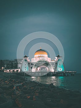 Vertical of the Melaka Malacca Straits Mosque illuminated at night in Malaysia