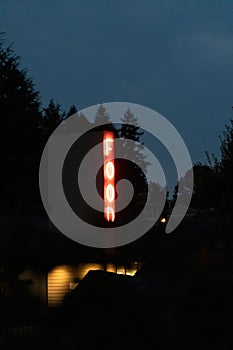 vertical neon sign glowing in the dark late at night