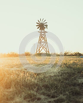 Vertical of an old windmill in a field at sunset in Texas