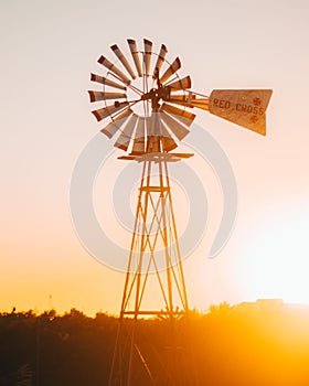 Vertical of an old windmill in a field at sunset in Texas