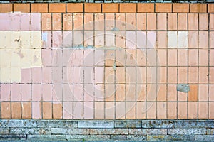 Vertical orange concrete tiles brick wall, pink or yellow paint. Text copy space