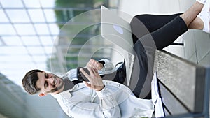 Vertical orientation of happy business man enjoy success on mobile phone. Joyful guy reading good news on smartphone in