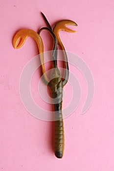 Vertical overhead shot of a fishing lure isolated on a pink background