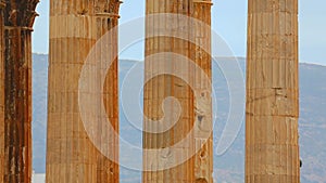 Vertical pan shot of tall marble columns, Corinthian capitals and architraves