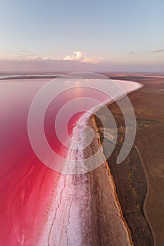 Vertical panoramic salty lake shore with pink salt at dusk after sunset. Aerial view