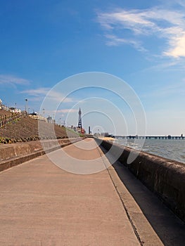 Vertical perspective view along the pedestrian promenade in blackpool with a view of the town north pier and tower