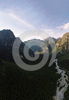 Vertical photo, Aerial view of the Dolra River, and Ushbi waterfall at distance. forest and high Caucasian mountains. way to Ushba