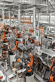 Vertical photo of automobile production line. Modern car assembly plant. Auto industry. Interior of a high-tech factory