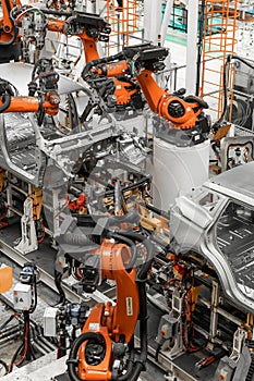 Vertical photo of automobile production line. Modern car assembly plant. Auto industry. Interior of a high-tech factory