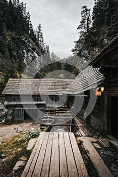 Vertical photo of a beautiful wooden cabin deep in the forest - Mlyny Oblazy Slovakia. Old wooden mill with rocks on background