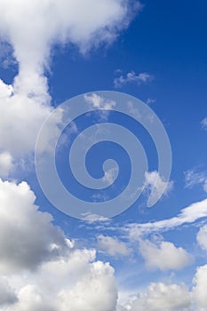 Vertical photo. Blue sky and white clouds in a circle. Frame made of white clouds on a sunny day