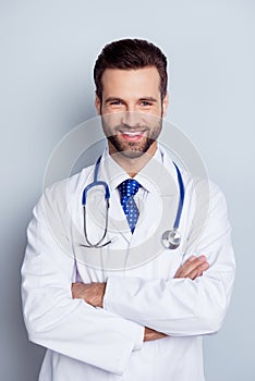 Vertical photo of cheerful smiling doc standing with crossed han