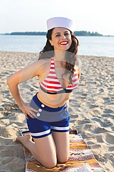 Vertical photo of a dark-haired european girl in a swimsuit on the beach