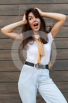 Vertical photo of emotional positive happy joyful pretty young brunette woman in trendy outfit. Beautiful attractive