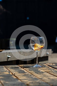 Vertical photo of empty wine glass on wooden table.