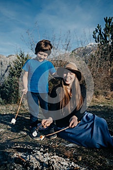 Vertical photo Family Camping: mother and son in forest Toastin