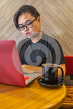 Vertical photo of hipster style lesbian using laptop at cafe