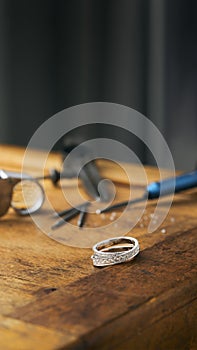 Vertical photo of a jeweller engraver tools and golden ring