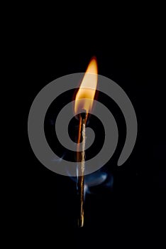 Safety match on black background with flaming head