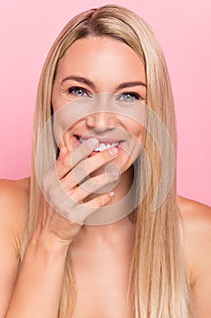 Vertical photo of positive lady touch her toothy smile enjoy aesthetic bodycare treatment  over pink color