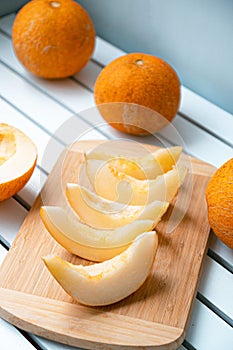 Vertical photo of ripe melon and melon slices on wooden board