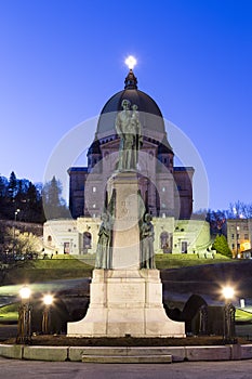 Vertical photo of the statue of St. Andre in front of St. Josephâ€™s Oratory of Mount Royal at sunrise