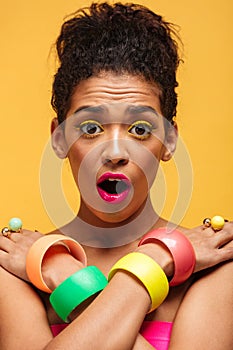 Vertical photo of surprised african woman in colorful adornment