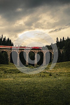 Vertical photo of train on a viaduct in the forest of Telgart -Slovakia with moody and dramatic sky before storm