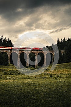 Vertical photo of train on a viaduct in the forest of Telgart -Slovakia with moody and dramatic sky before storm