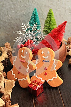Vertical photo of two gingerbread men and colorful trees