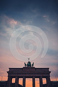 Vertical photo of Upper part of brandenburg gate in berlin on a colorful evening with picturesque clouds. Colossal monument in