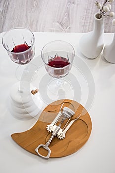 Vertical photo. the view from the top. Red wine , wine glass, corkscrew. white table, decoration corner . at home. Restaurant