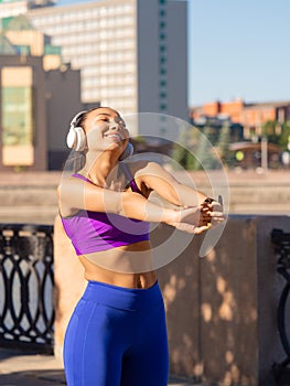Vertical photo of a woman stretching body - warming up before running or working out. Female runner stretching arms