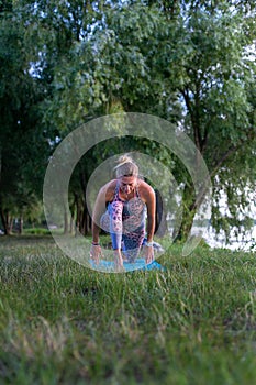 Vertical photo of a young woman doing yoga in nature