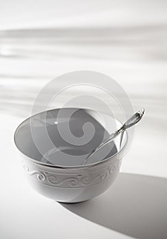 Empty White Bowl with Spoon on a White Background