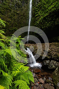 Vertical photograph of a small cascade under the main waterfall of Caldeirao Verde valley.