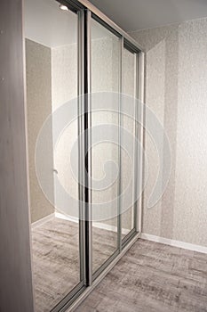 Vertical picture of big gray wardrobe with glass doors