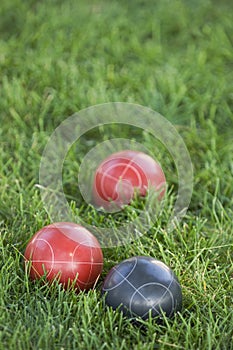 Vertical picture of colourful bocce balls on the lawn under the sunlight with a blurred background