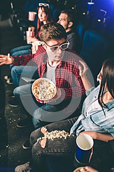 Vertical picture of guy talking to girl He is apologizing for popcorn that was spilled on girl`s pants and legs. She is