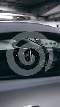 Vertical picture of a steering wheel in a grey car