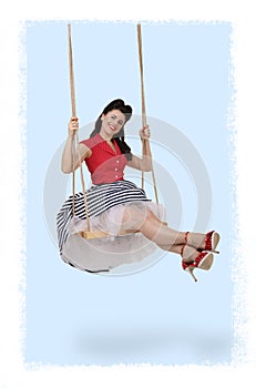 Vertical pin-up photo of a brunette girl on a swing