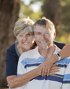 Vertical portrait of American senior beautiful and happy mature couple around 70 years old showing love and affection smiling toge