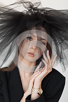 Vertical portrait of attractive, mystery, fashionable brunette woman in black dress and veil. Mourning outfit. Close up