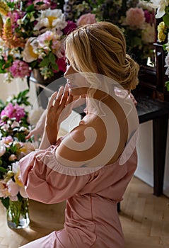 Vertical portrait from the back of a cute blonde surrounded by flowers